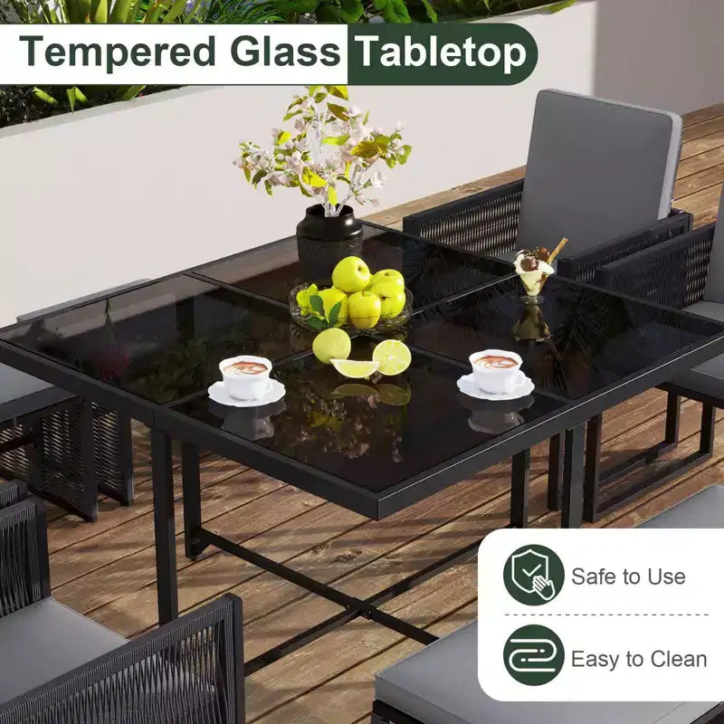 Set da pranzo da patio Costway da 9 pezzi con sedie in rattan PE, tavolo in vetro temperato e pouf